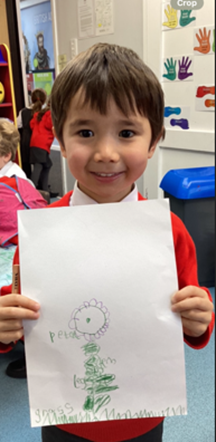 Reception child holding up their plant picture