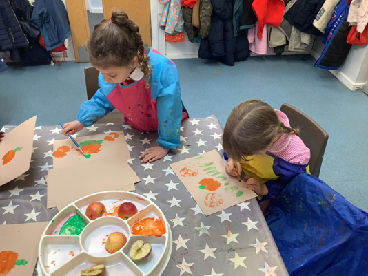 Reception children painting Harvest Festival paintings