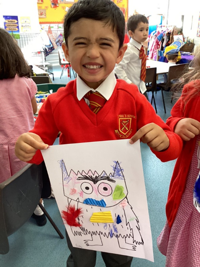 Child holding up a piece of art work