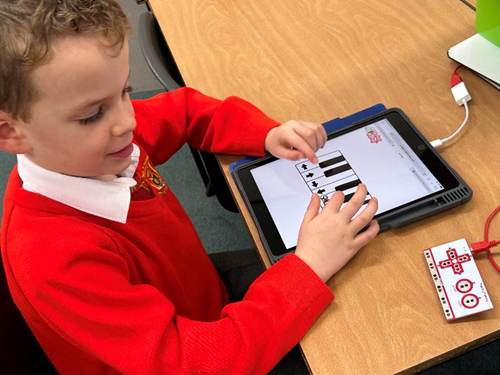 Child making their own piano using a ruler