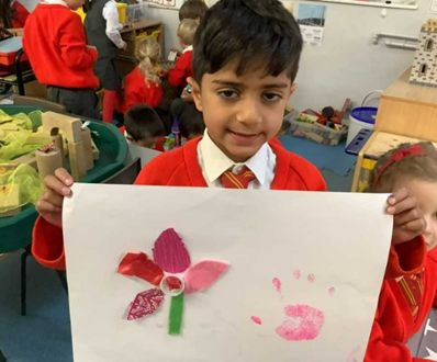 Reception child holding up their plant picture